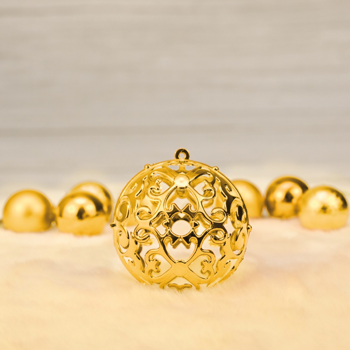 W zestawie można znaleźć bombki złote z wyciętą strukturą z symetrycznymi wzorami przypominające np. koronkę.